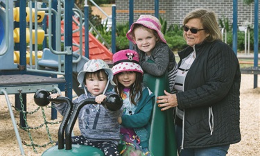 Children laughing and playing on a playground on cold melbourne day