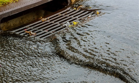 Water flowing over a flooding drain.
