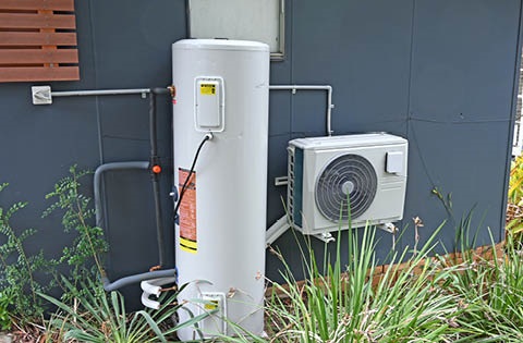 a heat pump hot water system on the outside of a house