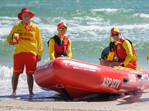Three lifesavers and a rescue boat at the beach