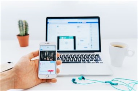 image of a laptop and phone open on facebook
