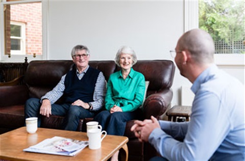 An elderly couple meeting with an access care staff member