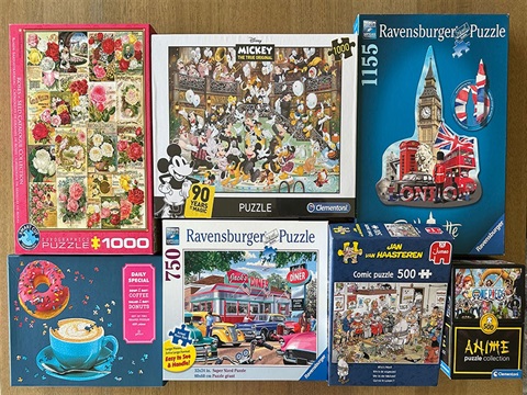 boxes of different puzzles laid out on a table