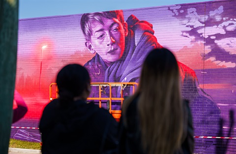 People watching an artist at the Wall to Wall Festival.