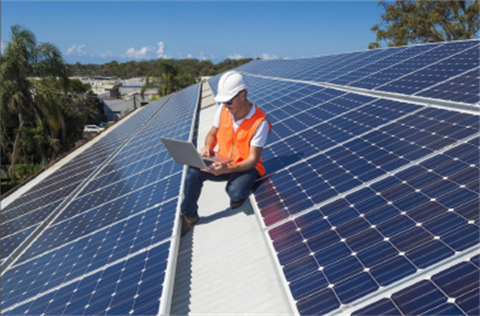 Worker on roof with solar panels