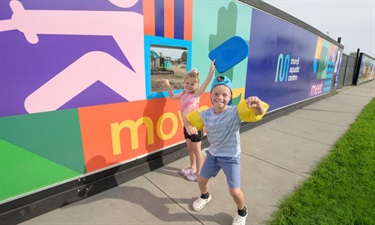 Local school kids take a look at the progress through the new viewing windows in the colourful hoarding on Governor Rd.