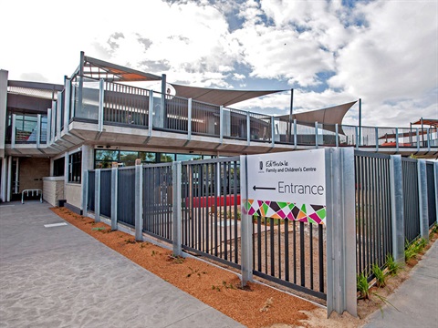 External view of a chidacre centre. A sign afixed to the front fence reads 'Edithvale Family and Childrens Centre Entrance' with an arrow pointing towards the door.