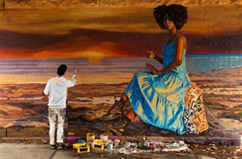Image of an muralist painting a wall