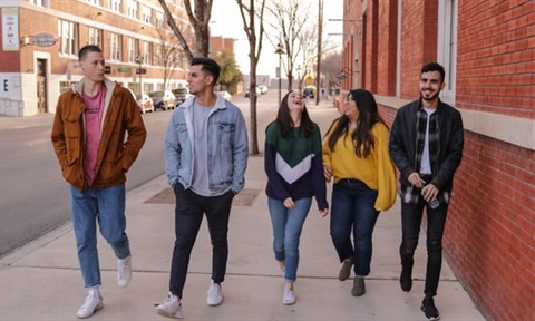 Youths walking down a footpath laughing.