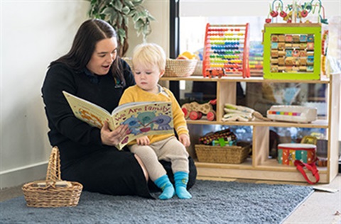 An early learning supervisor reading to a child inside our childcare centre.